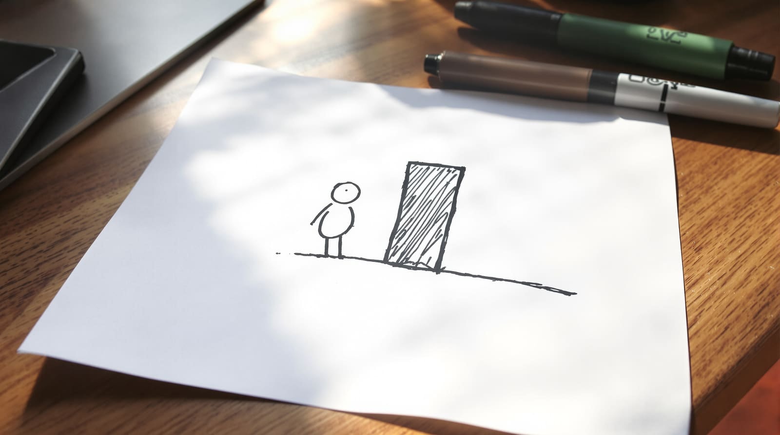 A crude marker cartoon of a small figure beside a tall shape, drawn on cheap paper